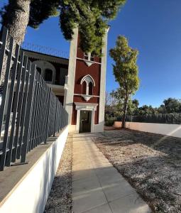 a fence in front of a building with a clock tower at Liberty Villa 2 in Bari