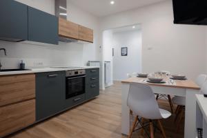 a kitchen with a counter and a table with chairs at [Centro Storico] Moderno Trilocale con Balcone in Trieste