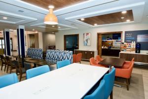 a dining room with tables and chairs and a cafeteria at Holiday Inn Express Hotel & Suites St. Charles by IHG in St. Charles