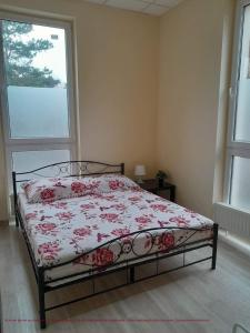 1 dormitorio con 1 cama con edredón de flores y ventana en Lubelski, en Varsovia