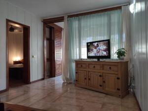 ein Wohnzimmer mit einem TV auf einer Holzkommode in der Unterkunft La Dolce Casa in Costa Del Silencio