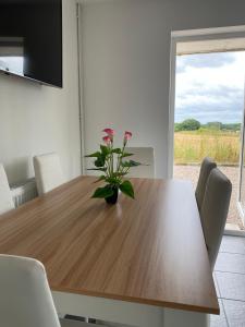 a dining room table with a vase of flowers on it at Cosy bungalow with views, walks, garden & parking. in Worcester