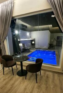 a room with a swimming pool with a table and chairs at شاليهات z5 الفندقية in Al ‘Awājīyah