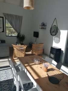 a living room with a wooden table and chairs at Matjesfontein Estate Keurbooms Chalet in Plettenberg Bay