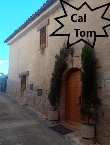 La Vilella BaixaにあるCal Tomの木の扉と猫の墓のある建物