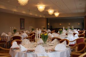 AlversundにあるAlver Hotelの白いテーブルと椅子が備わる宴会場