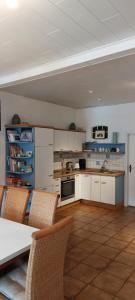 eine Küche mit weißen Schränken sowie einem Tisch und Stühlen in der Unterkunft Landhaus Ferienwohnung Wagner in Weener