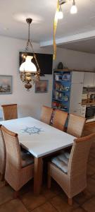 einen Esstisch mit Stühlen und einem Kronleuchter in der Unterkunft Landhaus Ferienwohnung Wagner in Weener