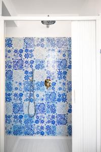 y baño con ducha de azulejos azules. en CASA DAMA, en Positano