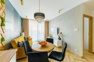 uma sala de estar com mesa e cadeiras em Mia Mare Premium Apartment by Perłowa Przystań Rent em Kolobrzeg