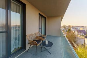 uma varanda com duas cadeiras e uma mesa em Mia Mare Premium Apartment by Perłowa Przystań Rent em Kolobrzeg