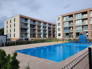 uma piscina em frente a dois edifícios de apartamentos em Mia Mare Premium Apartment by Perłowa Przystań Rent em Kolobrzeg