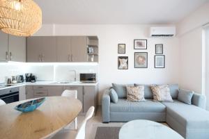 a living room with a blue couch and a table at Daphne by halu! : Downtown family penthouse in Thessaloniki