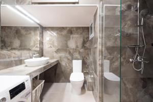 a bathroom with a toilet and a sink and a shower at Daphne by halu! : Downtown family penthouse in Thessaloniki