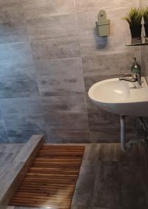 La salle de bains est pourvue d'un lavabo et de carrelage. dans l'établissement Άνετη κατοικία με κήπο, à Kastoria
