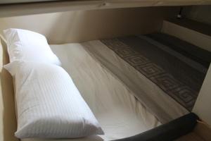 a white bed with two pillows on top of it at Barco Frapé in Barcelona