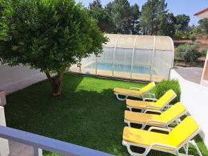 a group of chairs sitting on a lawn with a pool at casa Jone in Tomar
