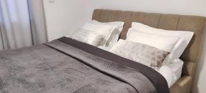 - un lit avec des oreillers blancs dans l'établissement " ARADA " Luxury House, à Arad