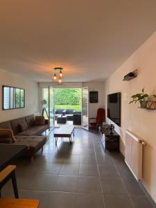 a living room with a couch and a table at Agréable Loft aux portes de bordeaux in Artigues-près-Bordeaux