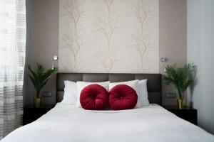 2 almohadas rojas sentadas encima de una cama en Krawiecka 3 - Merilyn Monroe style - 5 People, en Wroclaw