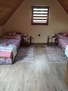 een slaapkamer met 2 bedden en 2 tapijten bij Magdaléna Vendégház in Bük