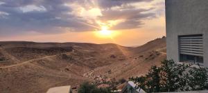 - une vue sur le désert au coucher du soleil depuis un bâtiment dans l'établissement " ARADA " Luxury House, à Arad