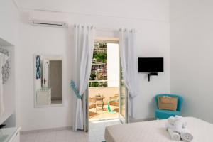 Schlafzimmer mit einem Bett und Blick auf einen Balkon in der Unterkunft CASA DAMA in Positano