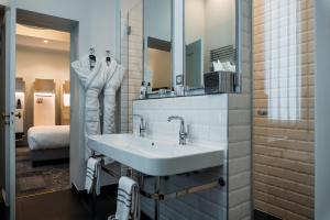 a bathroom with a sink and a mirror at Normandy Le Chantier in Paris +39 photos