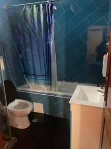 W wyłożonej niebieskimi kafelkami łazience znajduje się toaleta i umywalka. w obiekcie Tarrafal House w mieście Tarrafal