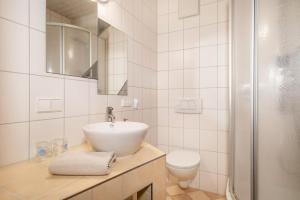 La salle de bains blanche est pourvue d'un lavabo et de toilettes. dans l'établissement Lemkamp klein, à Markdorf