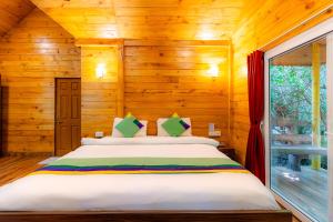 a bedroom with a bed in a wooden cabin at Treebo Trend Rock Valley in Ponda