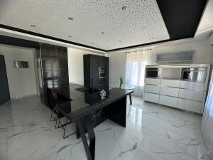 cocina grande con mesa negra y electrodomésticos en T4 TRES HAUT STANDING 130 mètres carré 