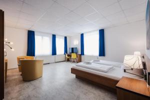 1 dormitorio con 2 camas, mesa y sillas en Hotel Seeblick, en Barhöft