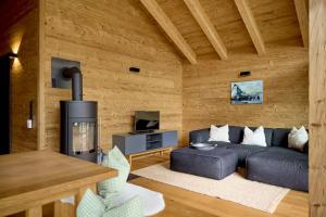 sala de estar con sofá y chimenea en PLUENGGAS-CHALETS, en Gaschurn