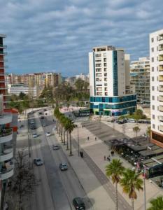 uma rua da cidade com carros e palmeiras e edifícios em Paradise Dream 3 Apartment in Vlora em Vlorë