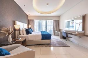 a bedroom with a bed and a desk and a couch at Quill Residence at Paramount Towers 3 BR Creek View in Dubai