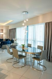 a dining room with a glass table and chairs at Quill Residence at Paramount Towers 3 BR Creek View in Dubai