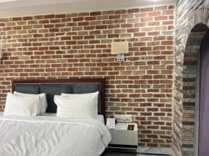 a bedroom with a brick wall and a bed at Hotel Hayatt Sukkur in Kalar Goth