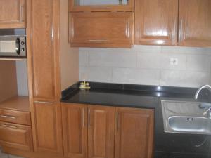 a kitchen with wooden cabinets and a black counter top at Bien situé T4 à Oran in Oran