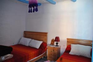 1 dormitorio con 2 camas y mesita de noche con lámpara en Ferme Dar Aicha green Bellouta, 