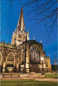 a large cathedral with a steeple and benches in front of it at The George Wright Boutique Hotel, Bar & Restaurant in Rotherham