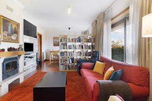 een woonkamer met een rode bank en een open haard bij Villa Luzya in Viana do Castelo