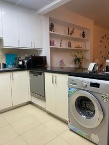 a kitchen with a washing machine in a kitchen at Sunset Oasis: Beachfront Studio in Dubai