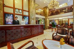 two people standing at a bar in a restaurant at Conifer Boutique Hotel in Hanoi