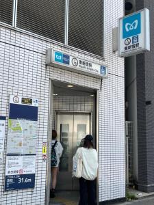 two people are standing outside of a building at City Hotel Dolphin in Tokyo