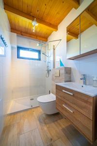 a bathroom with a tub and a toilet and a sink at Wichrowe Domki Plus in Władysławowo