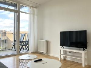 ein Wohnzimmer mit einem Flachbild-TV und einem großen Fenster in der Unterkunft Three Bedroom Apartment In Vejle, St, Grundet Alle 10, in Vejle