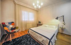 1 dormitorio con 1 cama, 1 silla y 1 lámpara de araña en Stunning Apartment In Carballo With 2 Bedrooms, en Carballo