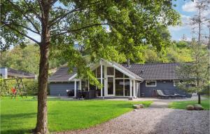 エーベルトフトにあるAmazing Home In Ebeltoft With 4 Bedrooms, Sauna And Wifiの庭の木のある家