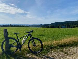 Una bicicleta estacionada junto a una valla en un campo en Chata Eliška, en Příkrý